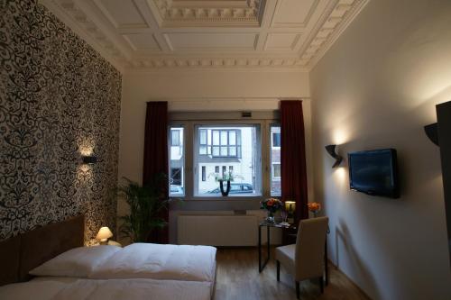 a bedroom with a bed and a window at Hotel Stern in Düsseldorf