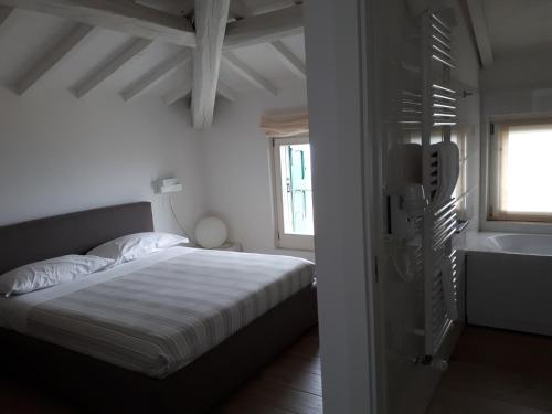 een witte slaapkamer met een bed en een raam bij Casa Selene Rocchi in Savignano sul Panaro