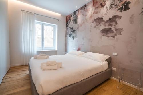 ペルージャにあるNIMA Boutique Houseの白いシーツが敷かれた大きなベッドのある寝室