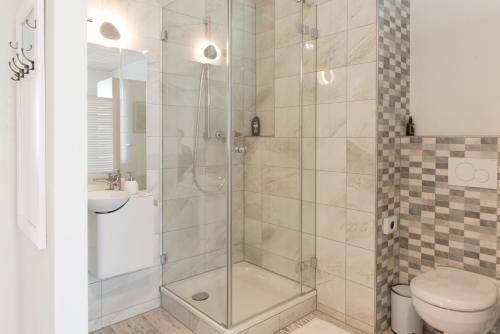 a bathroom with a shower with a toilet and a sink at Pension Geerlisburg in Kloten