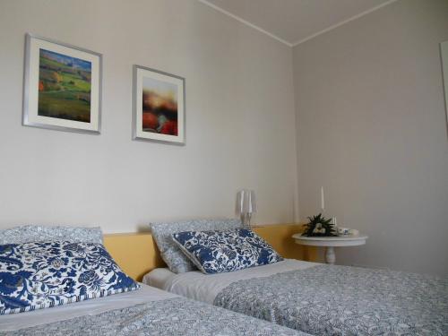 CarrùにあるI Perticaliの壁に2枚の写真が飾られたベッドルームのベッド2台