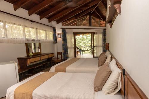 1 dormitorio con 2 camas y piano en Cabinas Las Olas, en Playa Avellana