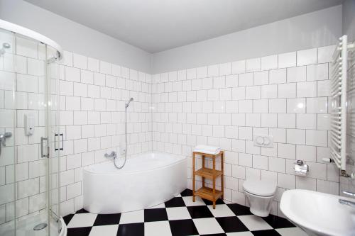 a bathroom with a tub and a sink and a toilet at Apartamenty Wratislavia in Wrocław