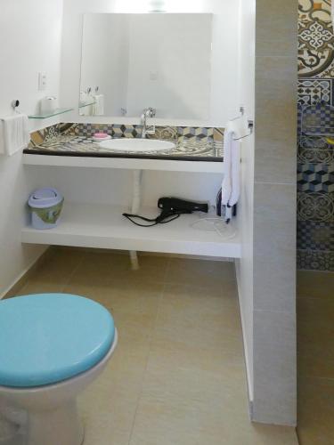a bathroom with a sink and a toilet at PIPA VILLA CAFE VERDE in Pipa