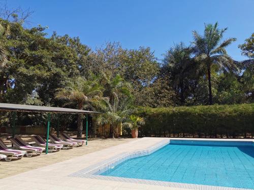 una piscina con sedie a sdraio e sedie accanto al resort di Tendinkoto Lodge a Sanyang