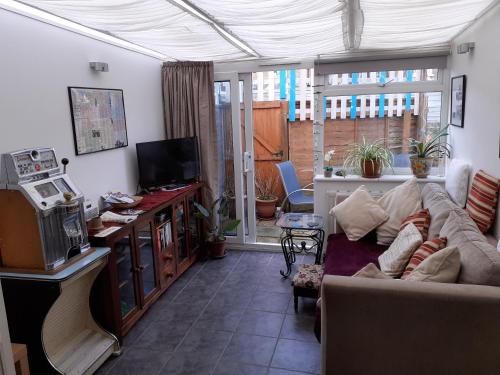 a living room with a couch and a tv at The Get Away in Margate