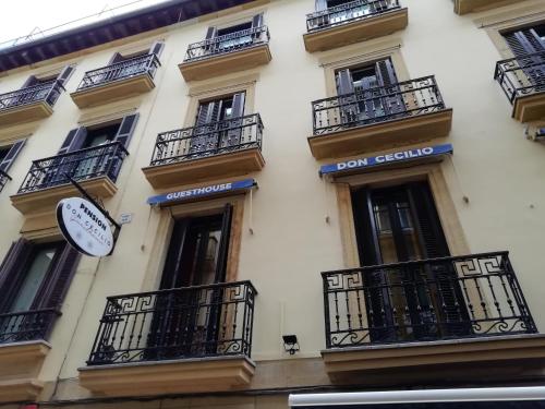 un edificio con balcones y un reloj en él en Don Cecilio Guesthouse (Parte Vieja), en San Sebastián