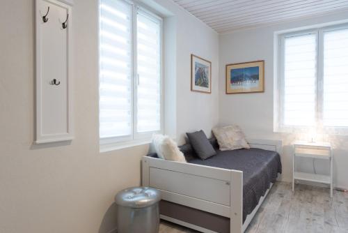 a bedroom with a bed and two windows at Pension Geerlisburg in Kloten