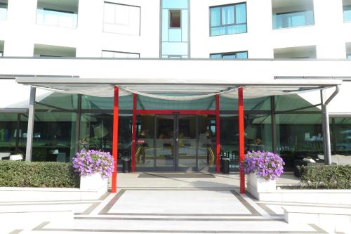 a building with flowers in front of it at ibis Styles Milano Est Settala in Settala