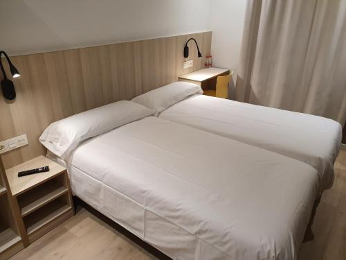 מיטה או מיטות בחדר ב-Hostal Conde Güell