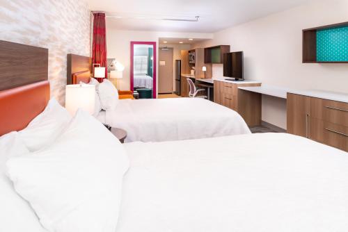 a hotel room with two beds and a kitchen at Home2 Suites By Hilton Columbus/West, OH in Columbus
