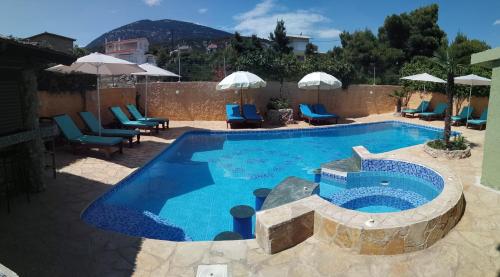 uma piscina com cadeiras e guarda-sóis ao lado em Xenonas ΚITHΑIRON em Vília