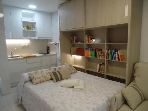 a small bedroom with a bed and a kitchen at VICO Estudio con parking in Almuñécar