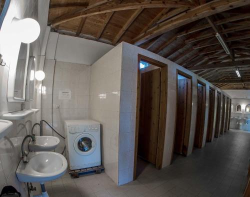 a bathroom with a washing machine and a washer at Camping Pitsoni in Sykia Chalkidikis