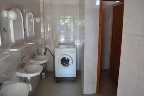 uma casa de banho com 2 lavatórios e uma máquina de lavar roupa em Camping Pitsoni em Sikia