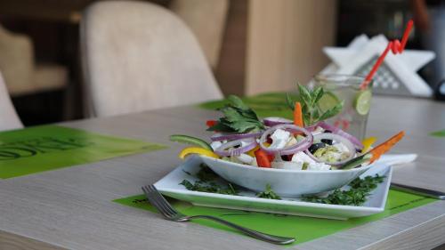 a bowl of salad on a plate on a table at Rivoli Suites in Hurghada
