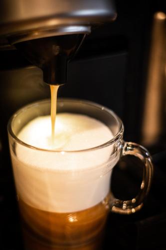 a coffee maker pours coffee into a cup at Boutique Lodge Spycher in Saas-Fee