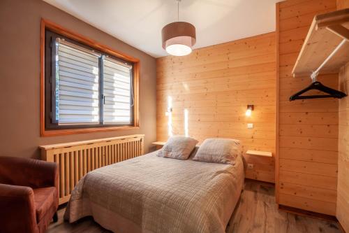 une chambre avec un lit, une fenêtre et une chaise dans l'établissement Efanle 1, à Morzine
