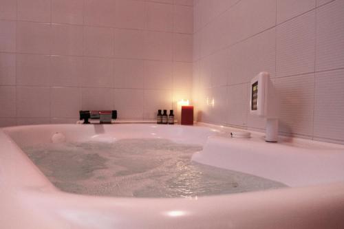 a white bathroom with a tub with water in it at Casa Chiara Plus in Porto Recanati