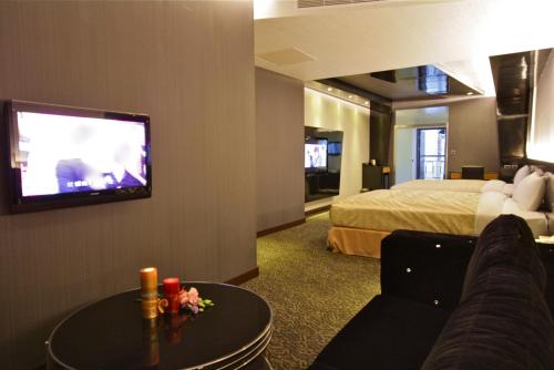 um quarto de hotel com uma cama e uma televisão de ecrã plano em Fairy Tale City Motel em Hualien