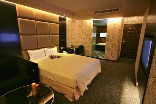 a hotel room with a bed and a mirror at Fairy Tale City Motel in Hualien City