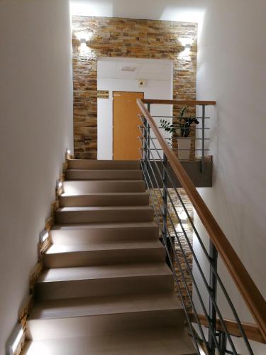 a stairway with a stone wall and a brown door at Agro Complex Apartments in Nitra