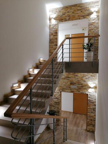 a staircase in a house with a stone wall at Agro Complex Apartments in Nitra