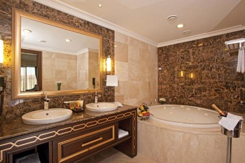 a bathroom with two sinks and a tub and a mirror at Crowne Plaza Istanbul Asia by IHG in Istanbul