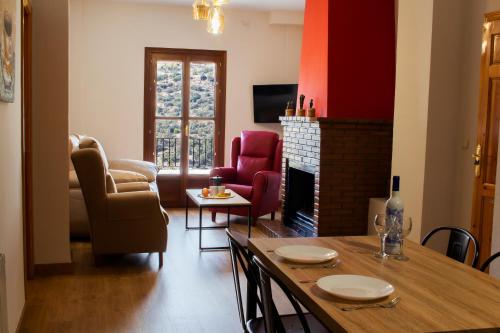 a living room with a table and a fireplace at Puerta Bubión Apartamentos in Bubión