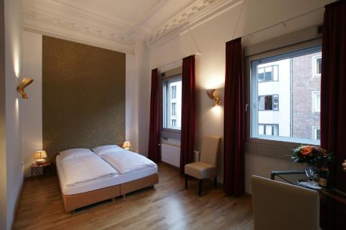 a bedroom with a bed and a large window at Hotel Stern in Düsseldorf