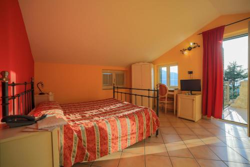 een slaapkamer met een bed, een bureau en een televisie bij Villa Al Rifugio in Cava deʼ Tirreni