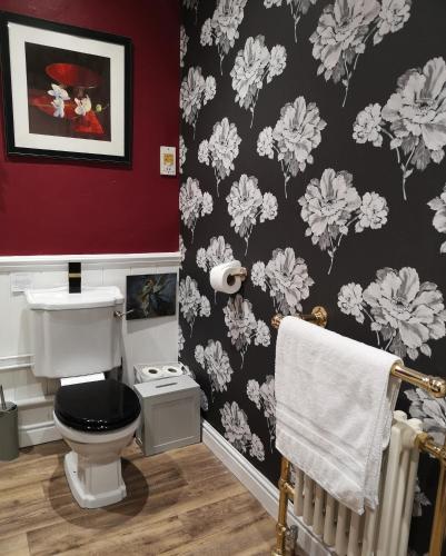 a bathroom with a black and white flower wallpaper at The Prophecy of Light Retreat in Glastonbury