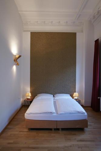 a bedroom with a bed and two lamps on two tables at Hotel Stern in Düsseldorf
