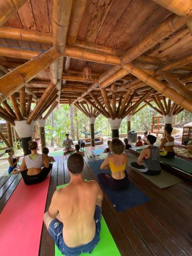 a group of people sitting in a yoga class at Universo Pol Bamboo Hostel in Morro de São Paulo