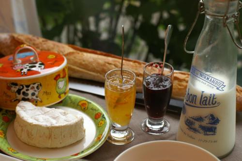 une table avec une assiette de nourriture et deux verres de boisson dans l'établissement GIVERNY COTTAGE, à Saint-Coulomb