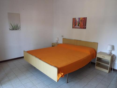 Schlafzimmer mit einem Bett mit orangefarbenem Laken in der Unterkunft Residenze Sul Mare in Martinsicuro