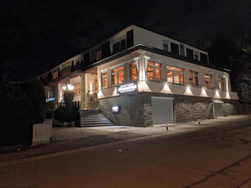 um edifício à noite com luzes acesas em Hotel Odenwaldblick em Rödermark