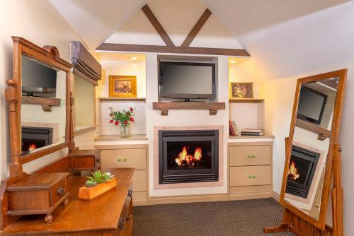 a living room with a fireplace and a tv at The Pierpont Inn in Ventura