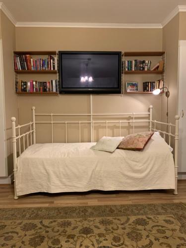 a bedroom with a bed with a flat screen tv on the wall at Furuliden Country Inn in Vittsjö