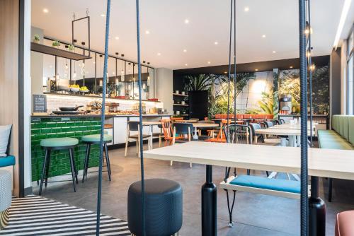 a restaurant with tables and chairs and a bar at Aparthotel Adagio Paris Montrouge in Montrouge