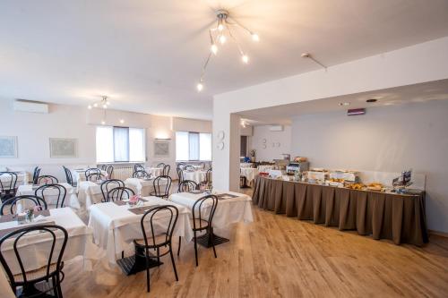 una sala de banquetes con mesas y sillas y un buffet en Hotel Bacco Rooms and Breakfast, en Pietra Ligure