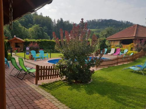 a backyard with a fence and chairs and a pool at Willa i domki Victoria in Wisła