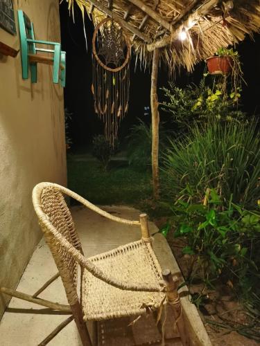 a wicker chair sitting on a patio at night at Cabañas Mannan in Tanchachín