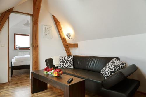 a living room with a black leather couch and a table at FeWo Jung in Falkensee