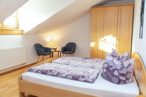 a bedroom with two beds and two chairs at Landhaus Altweck in Wegscheid