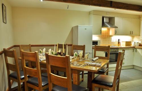 a kitchen and dining room with a table and chairs at THE OLD FARMHOUSE in Holmrook