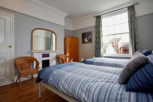 a bedroom with two beds and a mirror and a window at The Townhouse Central York in York