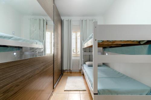 a room with two bunk beds and a mirror at casa das flores in Canoas