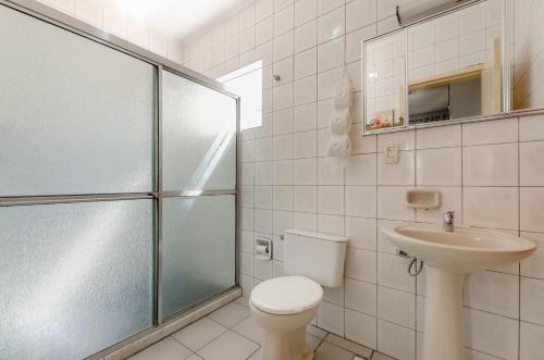 La salle de bains est pourvue de toilettes, d'un lavabo et d'une douche. dans l'établissement casa das flores, à Canoas