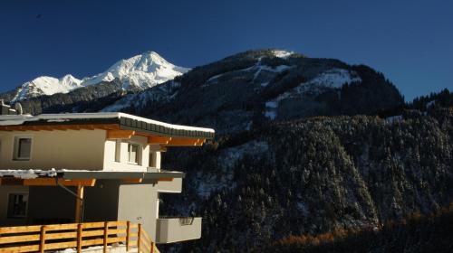 a house in front of a mountain with snow at Bergblick in Finkenberg